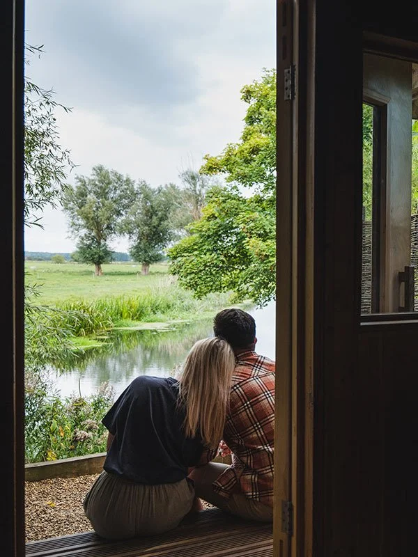 Two people on a porch looking out over the river